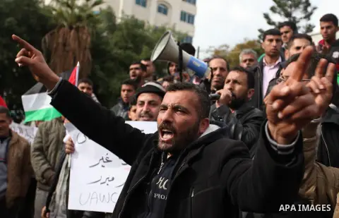 Palestinian workers shout slogans during a protest against the siege of Gaza, in Gaza City, on December 27, 2016. Photo by Ashraf Amra
