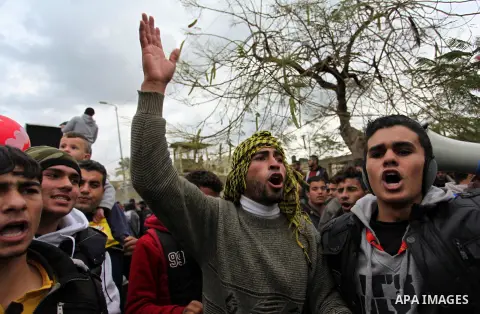 Palestinian workers shout slogans during a protest against the siege of Gaza, in Gaza City, on December 27, 2016. Photo by Ashraf Amra