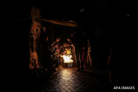 Palestinians warm themselves around a fire during the winter storm, outside their house at Al-Shate' refugee camp, in Gaza city, on December 27, 2016. Photo by Mohammed Dahman