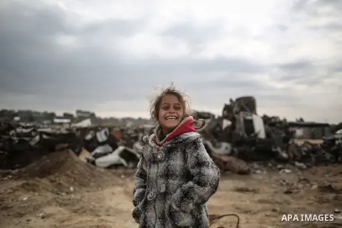 A Palestinian girl poses for a photo during rainy, cold weather outside her family house in a slum on the outskirts of Khan Younis refugee camp, southern Gaza Strip, on December 28, 2016. Photo by Mohammed Dahman