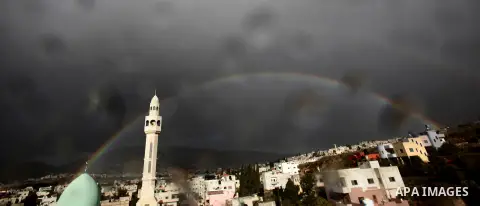 A rainbow is seen over the West Bank city of Nablus on December 31, 2016. Photo by Nedal Eshtayah