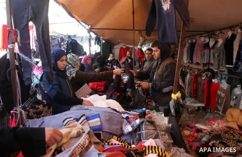 Palestinians shop at a market in Rafah in the southern of Gaza strip, on December 31, 2016. Photo by Abed Rahim Khatib