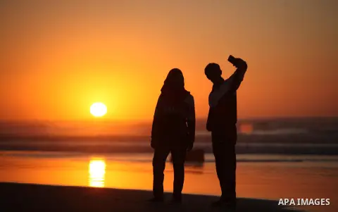 Palestinians take a selfie on the beach of Gaza City, during the last sunset of 2016, on December 31, 2016. Photo by Ashraf Amra