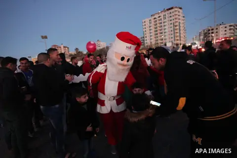 A Palestinian man in Santa Claus costume takes part in the celebration of the New Year at the Gaza seaport, on December 31, 2016. Photo by Ashraf Amra