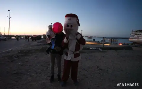 A Palestinian man in Santa Claus costume takes part in the celebration of the New Year at the Gaza seaport, on December 31, 2016. Photo by Ashraf Amra