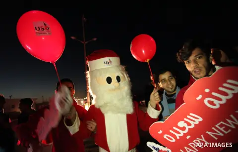 A Palestinian man in Santa Claus costume takes part in the celebration of the New Year at the Gaza seaport, on December 31, 2016. Photo by Ashraf Amra