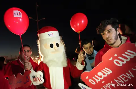 A Palestinian man in Santa Claus costume takes part in the celebration of the New Year at the Gaza seaport, on December 31, 2016. Photo by Ashraf Amra