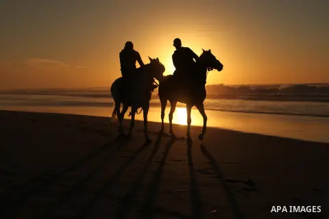 Palestinian men ride their horse as they enjoy the last sunset of 2016 at the beach of Gaza city, on the December 31, 2016. Photo by Ashraf Amra