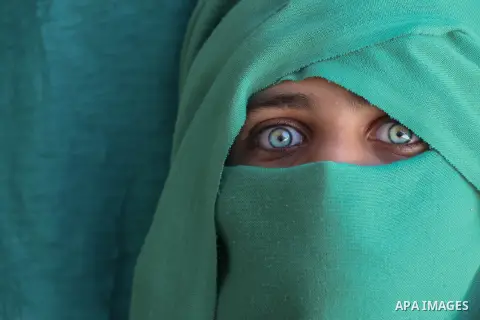 Cropped portrait of a girl with green eyes and green mask. Photo by Sanad Ltefa