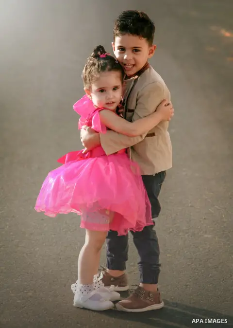 A boy hugs a pretty girl. Photo by Sanad Ltefa