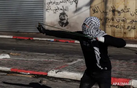 Palestinian protesters hurls a stones towards Israeli security forces during clashes with Palestinian protesters following the funeral of the martyr Tariq Badwan in the West Bank village of Azoun near Qalqilya, on Februa...
