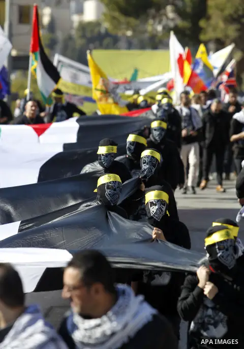 Palestinian supporters of the Fatah movement take part in a march to mark the 52nd anniversary of its creation in the West Bank City of Bethlehem, on January 1, 2017. Photo by Wisam Hashlamoun