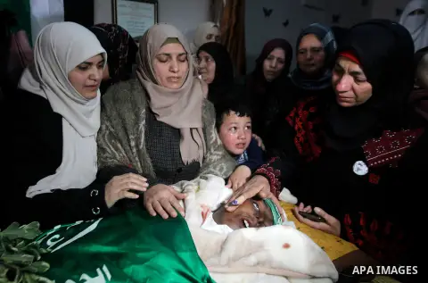 Relatives mourn over the body of Mohamed al-Rajabi, a Palestinian who was killed after reportedly carrying out a stabbing attack on Israeli soldiers months ago, during his funeral in the West Bank town of Hebron on Janua...