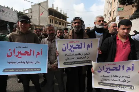 Palestinian supporters of the Islamic Jihad Movement, hold placards during a protest after Israeli police raided the unrecognized Bedouin village of Umm al-Hiran to evacuate residents in order to demolish their homes, in...