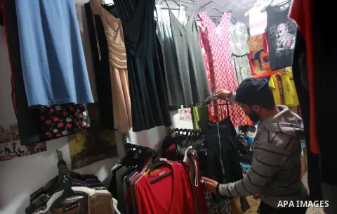 A Palestinian man looks at second hand clothes at a market in Gaza city, on January 21, 2017.Due to the current economic situation in Gaza Strip, many of the Palestinians resort to meet their needs of used goods. Photo b...