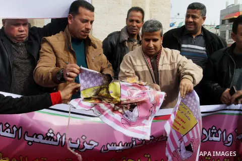 Palestinian protestors burn a placard depicting US President Donald Trump during a demonstration against his pledge to move his country's embassy to Jerusalem, in Rafah in the southern Gaza Strip on January 24, 2017. Tru...