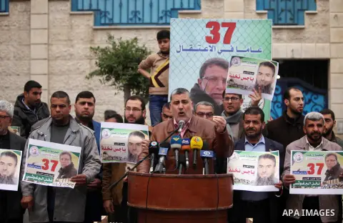 Palestinians hold placards during a protest to show solidarity with Palestinian prisoners in Israeli jails, in front of the high commissioner for human rights headquarters, in Gaza city, on January 26, 2017. Photo by Ash...