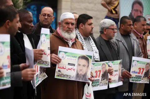 Palestinians hold placards during a protest to show solidarity with Palestinian prisoners in Israeli jails, in front of the high commissioner for human rights headquarters, in Gaza city, on January 26, 2017. Photo by Ash...