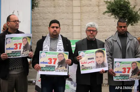 Palestinians hold placards during a protest to show solidarity with Palestinian prisoners in Israeli jails, in front of the high commissioner for human rights headquarters, in Gaza city, on January 26, 2017. Photo by Ash...