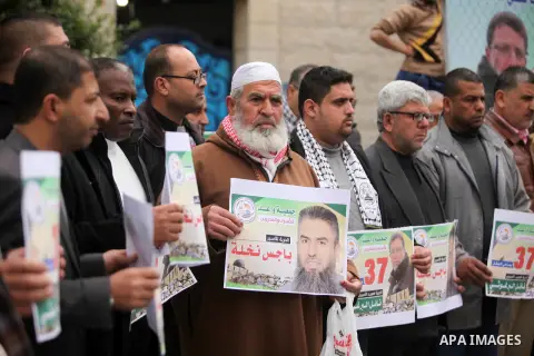 Palestinians hold placards during a protest to show solidarity with Palestinian prisoners in Israeli jails, in front of the high commissioner for human rights headquarters, in Gaza city, on January 26, 2017. Photo by Ash...