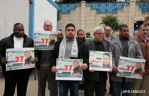 Palestinians hold placards during a protest to show solidarity with Palestinian prisoners in Israeli jails, in front of the high commissioner for human rights headquarters, in Gaza city, on January 26, 2017. Photo by Ash...