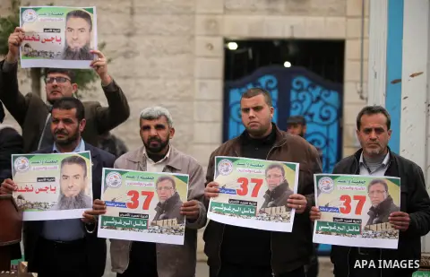 Palestinians hold placards during a protest to show solidarity with Palestinian prisoners in Israeli jails, in front of the high commissioner for human rights headquarters, in Gaza city, on January 26, 2017. Photo by Ash...