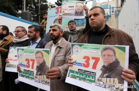 Palestinians hold placards during a protest to show solidarity with Palestinian prisoners in Israeli jails, in front of the high commissioner for human rights headquarters, in Gaza city, on January 26, 2017. Photo by Ash...