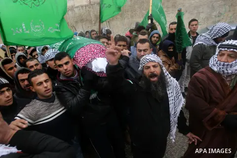 Mourners carry the shroud-wrapped body of Majd al-Khudur, a Palestinian woman who was killed by Israeli security forces during a car-ramming attack last year, during her funeral in the West Bank village of Bani Naim, nea...