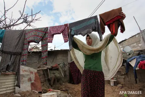 A Palestinian woman hangs laundry on a rope to dry outside her hovel during the cold weather in the Jabalia refugee camp in the northern Gaza Strip on January 29, 2017. Photo by Ashraf Amra
