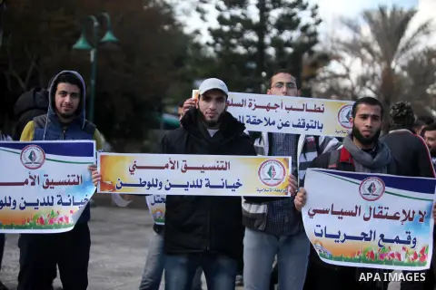 Palestinian supporters of the Islamic Jihad Movement hold placards during a protest against the security coordination and the political arrests in the West Bank, in Gaza city on January 31, 2017. Photo by Ashraf Amra