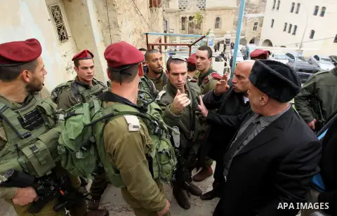 Palestinian protesters argue with Israeli army officers during a protest calling for reopening a closed street in the West Bank city of Hebron February 9, 2017. Photo by Wisam Hashlamoun