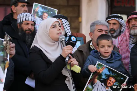 Palestinians hold posters bearing a portrait of Palestinian journalist Mohammed al-Qiq who is imprisoned in an Israeli jail during a protest in the West Bank city of Hebron, on February 10, 2017. Photo by Wisam Hashlamou...