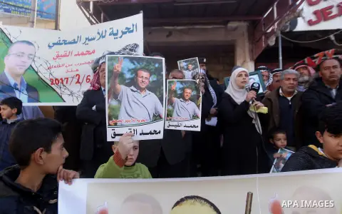 Palestinians hold posters bearing a portrait of Palestinian journalist Mohammed al-Qiq who is imprisoned in an Israeli jail during a protest in the West Bank city of Hebron, on February 10, 2017. Photo by Wisam Hashlamou...