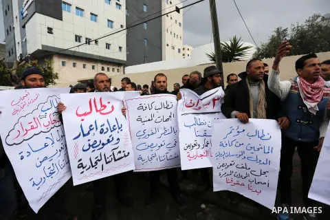 Palestinian owners of factories hold banners during a protest demanding to reconstruction their factories which was destroyed during the 50-day war between Israel and Hamas militants in the summer of 2014, in Gaza city o...