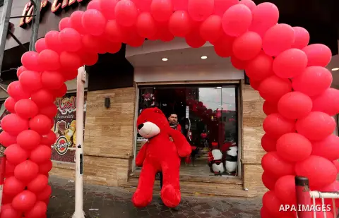 A Palestinian vendor carries a red teddy bear outside his shop on Valentine's day in Gaza city on February 14, 2017. Valentine's Day is increasingly popular in the region as people have taken up the custom of giving flow...