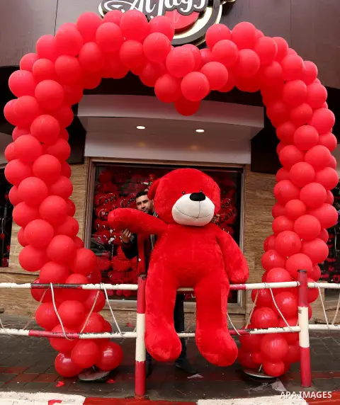 A Palestinian vendor carries a red teddy bear outside his shop on Valentine's day in Gaza city on February 14, 2017. Valentine's Day is increasingly popular in the region as people have taken up the custom of giving flow...