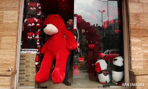 A Palestinian vendor carries a red teddy bear outside his shop on Valentine's day in Gaza city on February 14, 2017. Valentine's Day is increasingly popular in the region as people have taken up the custom of giving flow...