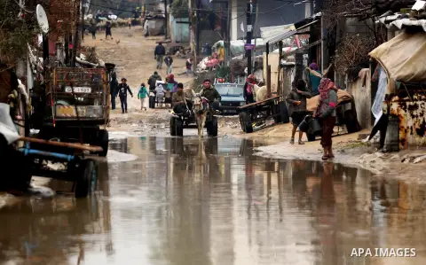 Palestinian men ride a donkey cart in a flooded area following heavy rainfall in the al-Moghraqa in the center Gaza Strip, on February 16, 2017. Photo by Ashraf Amra