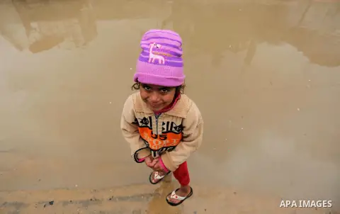 A Palestinian girl poses for a photo during a heavy rainfall, in the al-Moghraqa in the center Gaza Strip, on February 16, 2017. Photo by Ashraf Amra