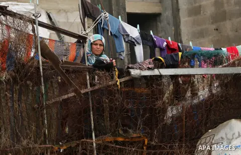 A Palestinian woman looks at her house during a heavy rainfall in Gaza city,on February 16, 2017. Photo by Ashraf Amra