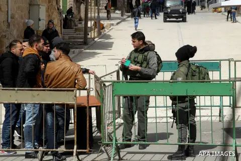 Israeli security forces inspect Palestinian identities during a protest after Friday prayers outside the Ibrahimi mosque calling for the removal of settlers and reopening of a closed street in the West Bank town of Hebro...