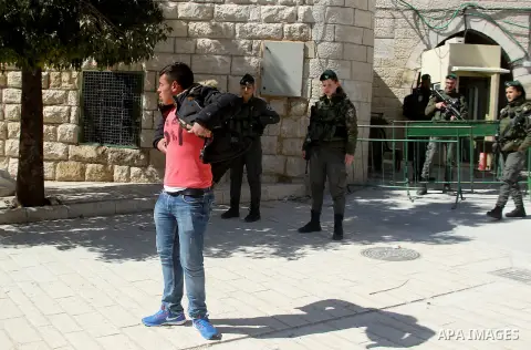 Israeli security forces inspect Palestinians during a protest after Friday prayers outside the Ibrahimi mosque calling for the removal of settlers and reopening of a closed street in the West Bank town of Hebron on Febru...