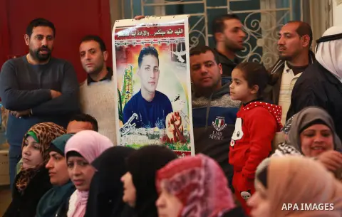 Palestinians hold placards during a protest to show solidarity with Palestinian prisoners held in Israeli Jails, in front of Red cross office in Gaza city, on February 20, 2017. Photo by Mohammed Asad