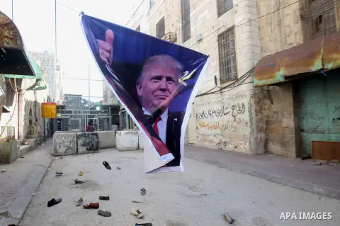 A general view shows old shoes being thrown by Palestinian demonstrator at a poster of US President Donald Trump as they protest against his support of Israel and demand for the Israeli army to re-open Shuhada Street whi...