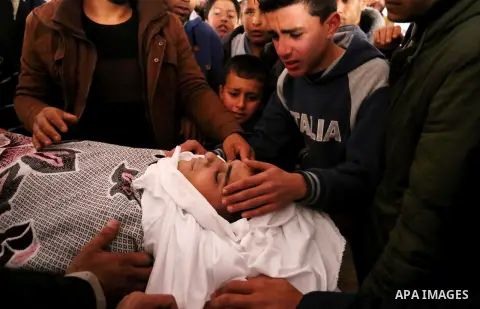 Palestinians mourn around the body of Palestinian Abdullah Alnamula, 23, who died after inhaling toxic gas inside the tunnel along the border between the Gaza Strip and Egypt during his funeral in Rafah in the southern G...