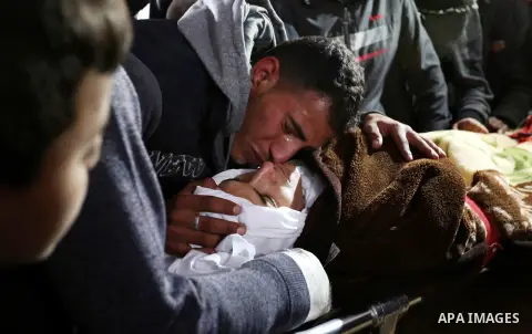 Palestinians mourn around the body of Palestinian Obeid Soufi, 25, who died after inhaling toxic gas inside the tunnel along the border between the Gaza Strip and Egypt during his funeral in Rafah in the southern Gaza st...