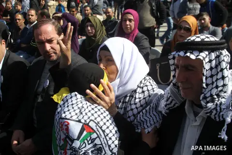 Masked Palestinians holds the pictures of Palestinian teenager Qusai Al-Amour, a 17-year-old who was shot dead, during a demonstration in the West Bank village of Tuqua, near Bethlehem, 26 February 2017. Emoor, a member...