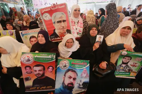 Palestinians hold placards during a protest to show solidarity with Palestinian prisoners held in Israeli Jails, in front of Red cross office in Gaza city, on February 27, 2017. Photo by Mohammed Asad