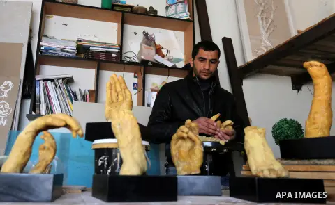 Palestinian artist, Mohammed Abu Hashish, 29, uses beeswax to produce models of human limb, at his workshop, in the al-Maghazi refugee camp, in the centre of the Gaza Strip, on February 27, 2017. Photo by Ashraf Amra