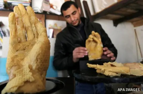 Palestinian artist, Mohammed Abu Hashish, 29, uses beeswax to produce models of human limb, at his workshop, in the al-Maghazi refugee camp, in the centre of the Gaza Strip, on February 27, 2017. Photo by Ashraf Amra